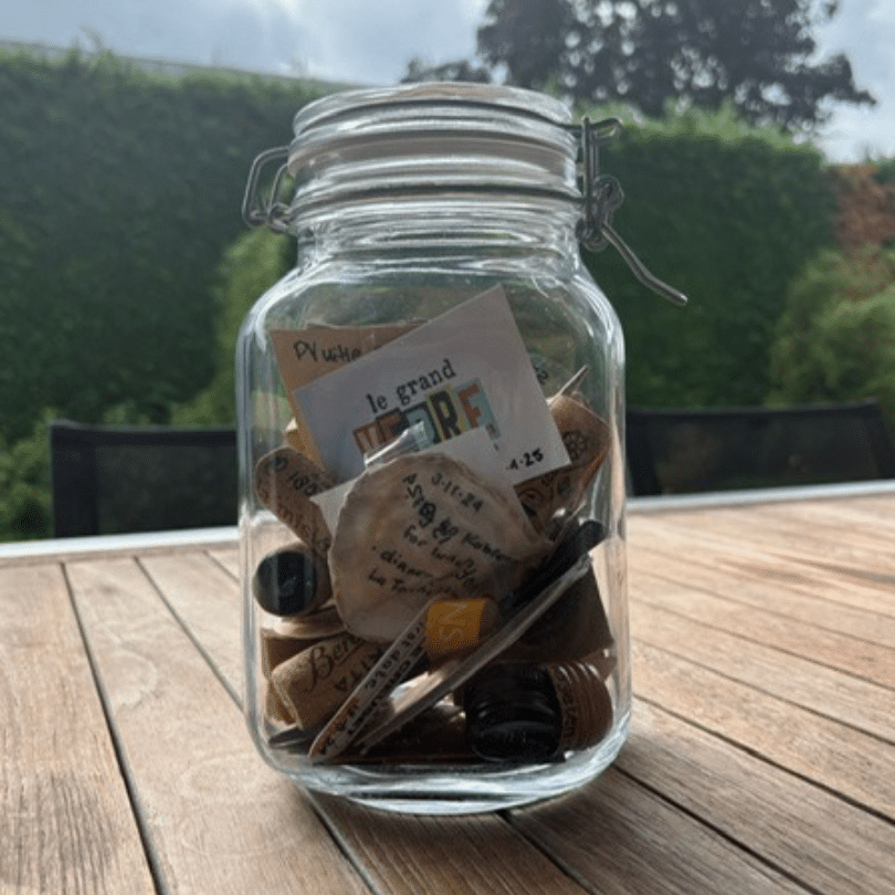 Johan & Ingrid 3 Een man en een vrouw met een hoog EQ omhelzen elkaar buiten, de ogen gesloten, terwijl de man zachtjes haar voorhoofd kust in een gebaar van troost en genegenheid. Beiden dragen blauw en zien er kalm en vredig uit tegen een achtergrond van groen.