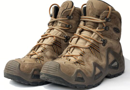 Een paar stoere bruine wandelschoenen met een hoge enkel, stevige zolen en gedetailleerde vetersluiting. De laarzen hebben zichtbare gebruikssporen, wat aangeeft dat ze zijn gebruikt voor buitenactiviteiten. Net als bij een duurzame relatie zorgen de talrijke oogjes en dikke veters voor een veilige pasvorm op uitdagende terreinen.